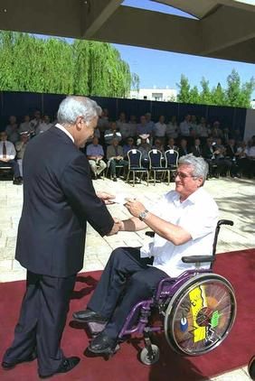 President Moshe Katsav presenting the ribbon to major (res.) Uri 