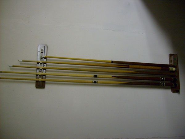 Set of five pool cues and rack